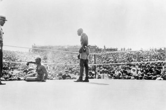 Jack Johnson standing over his opponent in the ring